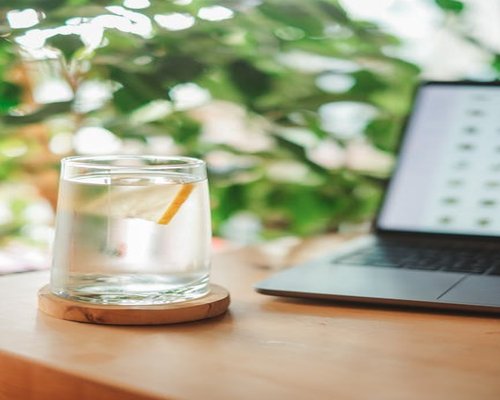 Glass of water with lemon slices on a desk